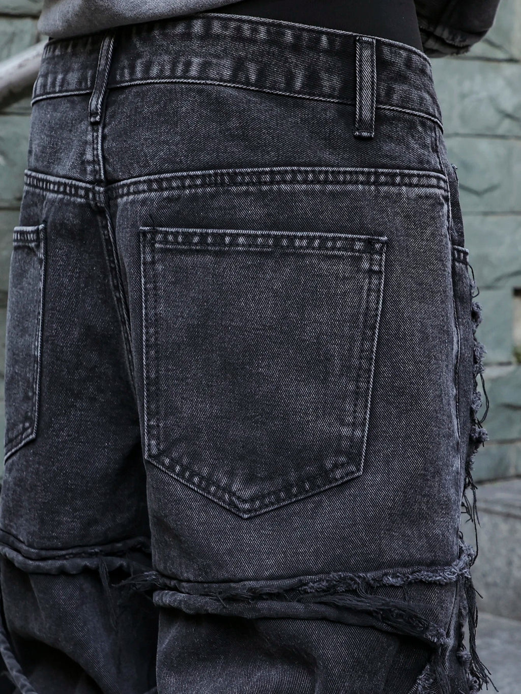 Men's black jeans. With a design of (ripped holes) and tassels. In a street trend style.